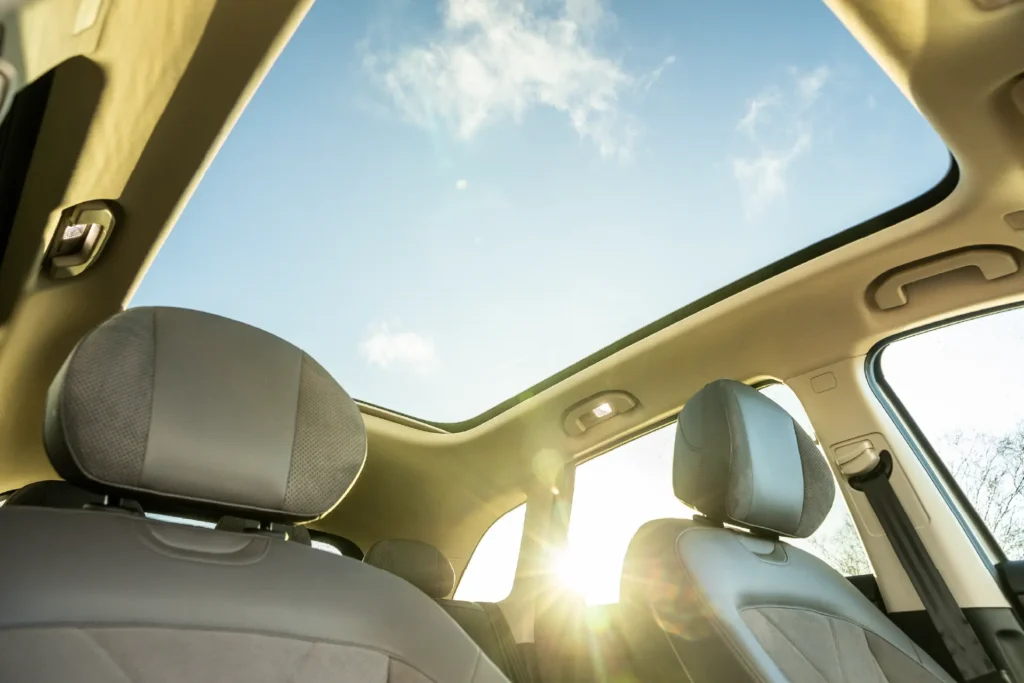 To forseter og åpent panoramatak i bilinteriør.